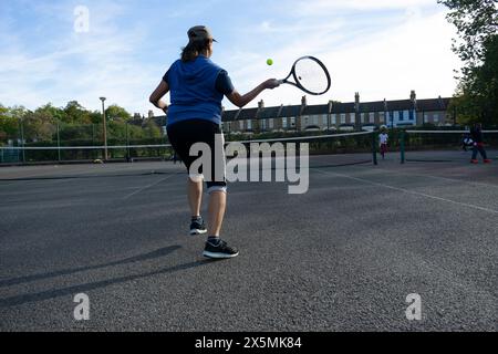 Gente che gioca a tennis sul campo di quartiere Foto Stock