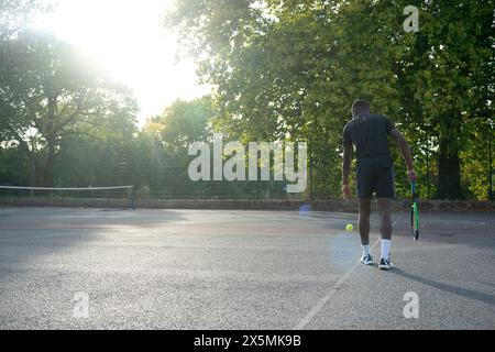 Uomo che gioca a tennis sul campo di quartiere Foto Stock