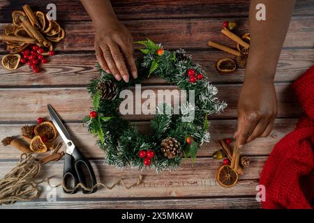 Fiorista che prepara la corona di Natale Foto Stock