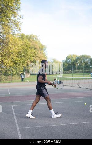 Uomo che gioca a tennis sul campo di quartiere Foto Stock