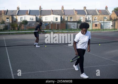Gente che gioca a tennis sul campo di quartiere Foto Stock