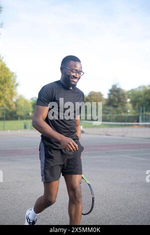 Uomo che gioca a tennis sul campo di quartiere Foto Stock