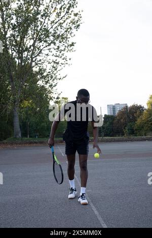 Uomo che gioca a tennis sul campo di quartiere Foto Stock