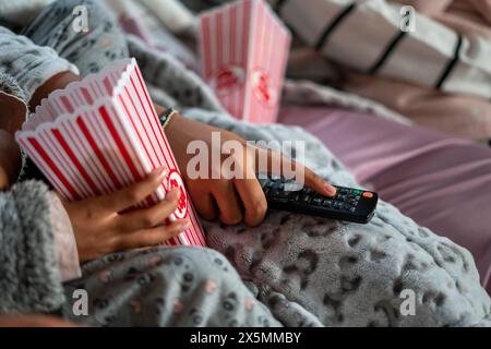 Primo piano di sorelle con telecomando e popcorn Foto Stock