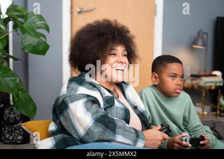 Madre e figlio giocano ai videogiochi a casa Foto Stock