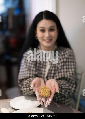 Donna che prepara torte lunari a casa Foto Stock