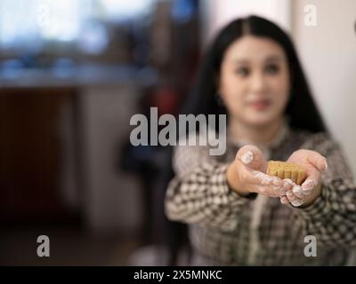 Donna che prepara torte lunari a casa Foto Stock