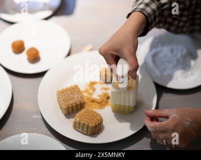 Donna che prepara torte lunari a casa Foto Stock