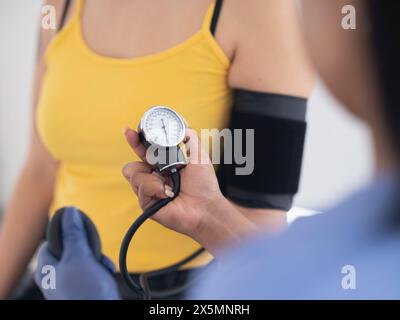 Primo piano di medici mani che controllano la pressione sanguigna dei pazienti Foto Stock