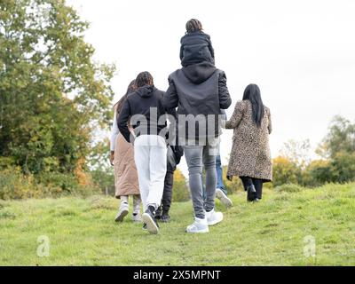 Vista posteriore della famiglia che cammina nel prato Foto Stock