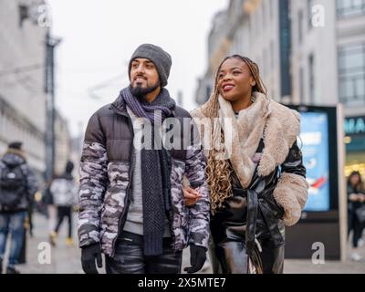 Giovane coppia sorridente che cammina in città Foto Stock