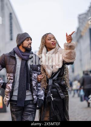 Giovane coppia sorridente che cammina in città Foto Stock