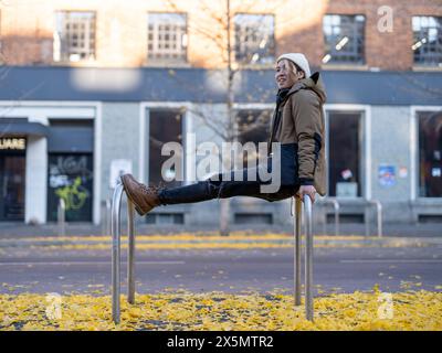 Uomo appoggiato al banco delle biciclette in città Foto Stock