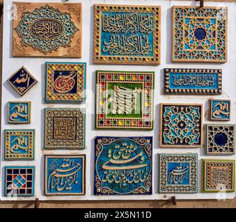 Yazd, Iran - 2024-03-03 - 03: Vivace esposizione di tradizionali piastrelle persiane decorate con calligrafia e motivi. Cattura l'essenza della cultura e dell'arte. Foto Stock