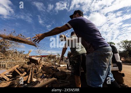 Lajeado, Brasile. 9 maggio 2024. I residenti eliminano i detriti dopo precipitazioni eccezionalmente pesanti nel sud del paese. Nello stato del Rio grande do sul, vaste aree di terra erano sott'acqua e strade e case sono state inondate. Più di 100 persone sono morte a causa della tempesta finora. Credito: Antonio Valiente/dpa/Alamy Live News Foto Stock