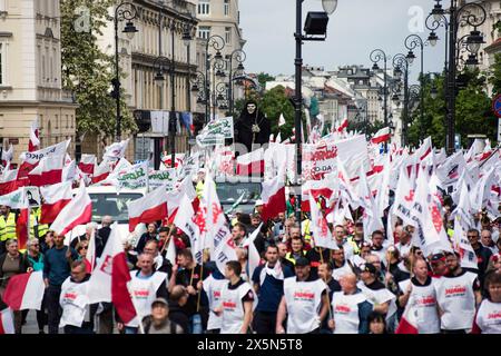 I manifestanti ondeggiano bandiere polacche e "solidarietà” e tengono cartelli durante la protesta contro il Green Deal dell'UE. I sindacati polacchi, gli agricoltori e gli oppositori del governo polacco pro-Unione europea si sono riuniti nel centro di Varsavia per protestare contro il Green Deal e le politiche climatiche dell'Unione europea. La marcia è stata organizzata dal sindacato indipendente autonomo "solidarietà” (NSZZ "Solidarnosc”) che rappresenta gli interessi degli agricoltori, che si oppongono fermamente alle politiche climatiche dell'UE, e dal partito conservatore nazionale di opposizione diritto e giustizia. Foto Stock