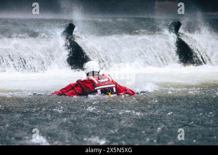 Vigile del fuoco in acqua sotto il pericoloso wier durante l'addestramento di salvataggio per annegamento. Foto Stock