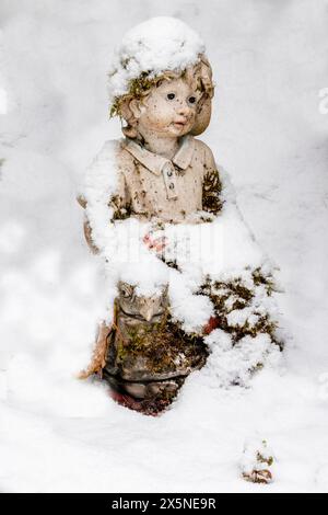 Stati Uniti, Stato di Washington, Sammamish. La neve fresca cade nell'arte del giardino nel cortile Foto Stock