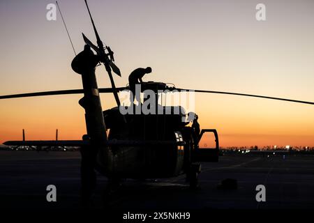 Yuma, Arizona, Stati Uniti. 3 aprile 2024. Hannah Kinder, UH-60L, meccanico elicotteri Black Hawk assegnato al 207th Aviation Troop Command, conduce la manutenzione post volo sul rotore principale durante il corso Weapons and Tactics Instructor 2-24 vicino alla Marine Corps Air Station Yuma, Ariz., 3 aprile 2024. Durante la scuola di sette settimane, due equipaggi dell'esercito Black Hawk hanno effettuato un intenso programma di missioni di combattimento simulate con aerei ad ala fissa e a rotazione della forza alleata e avversaria. L'iterazione di addestramento ha segnato la prima volta che il convenzionale U.S. Army UH-60 Foto Stock