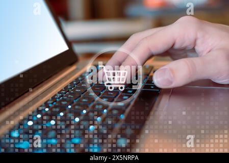 Digitazione manuale sul computer portatile con le icone del carrello. Concetto di shopping online. Shopping online senza interruzioni a portata di mano. Potenziare i consumatori moderni con Foto Stock