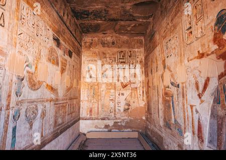 Arte murale sulle pareti del tempio a Medinet Habu, Luxor, Egitto, raffigurante scene di dei, faraoni e rituali religiosi. Foto Stock