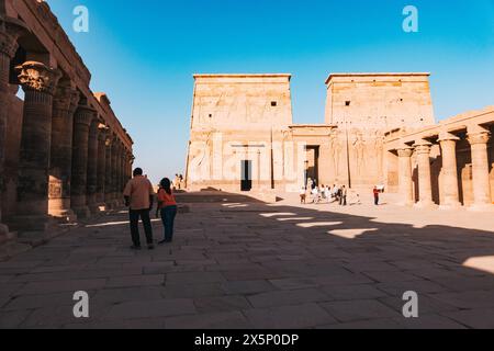 Turisti che esplorano l'antico Tempio di file ad Assuan, Egitto Foto Stock