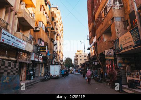 Una strada trafficata con varie bancarelle che vendono cibo e abbigliamento nella città di Assuan, in Egitto Foto Stock