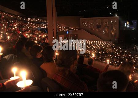 Persone che tengono in mano candele accese durante il servizio natalizio presso la chiesa battista di Thomas Road a Lynchburg, Virginia, USA Foto Stock