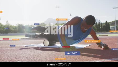 Un uomo che utilizza un rullo in schiuma sul campo per l'addestramento Foto Stock