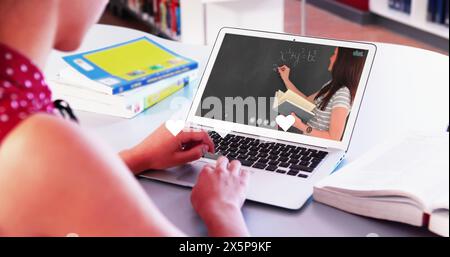 Immagine di icone del cuore sopra una donna caucasica che utilizza un laptop Foto Stock