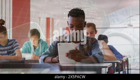 Immagine di grafici e tabelloni commerciali su studenti multirazziali che utilizzano tablet digitali in classe Foto Stock