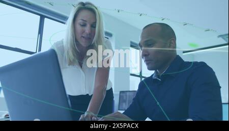 Collega caucasico anziano e collega birazziale che guarda un notebook Foto Stock