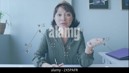 Immagine di grafico con numeri che cambiano su una donna d'affari asiatica che parla di immaginazione Foto Stock