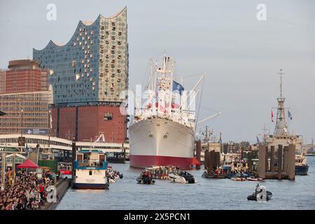 Amburgo, Germania. 10 maggio 2024. Numerosi visitatori si sono riuniti al Landungsbrücken dopo il tramonto durante il 835° compleanno del porto di Amburgo. La sala concerti Elbphilharmonie e la nave 'Cap San Diego' possono essere viste sullo sfondo. Crediti: Georg Wendt/dpa/Alamy Live News Foto Stock