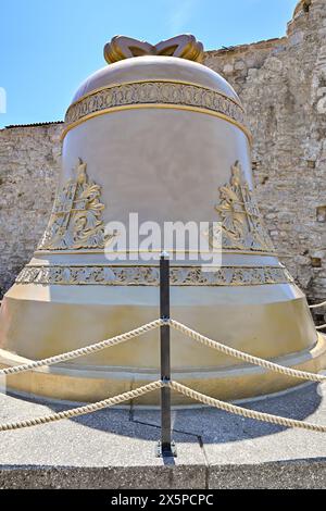 Budva campanella lungo le mura della fortezza sullo sfondo del paesaggio della città in estate a Budva, Montenegro. Foto Stock