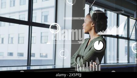 Immagine di grafici, barre, cerchi, donna birazziale che controlla il cellulare guardando attraverso la finestra Foto Stock