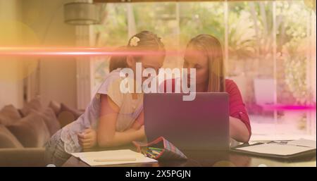 Immagine della luce che si muove sopra la figlia e la madre caucasiche felici che lavorano su un laptop a casa Foto Stock