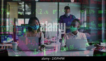 Immagine di un tabellone commerciale e grafico su diversi colleghi che indossano una maschera che parla e lavora su un computer portatile Foto Stock