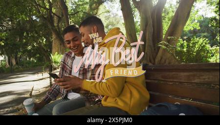 Immagine del testo del mio migliore amico su amici birazziali maschi felici utilizzando lo smartphone Foto Stock