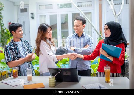 Due giovani donne piuttosto diverse che si occupano di riunioni d'affari in un moderno luogo di lavoro all'aperto. Concetto di business multirazziale che lavora insieme per Brain Foto Stock