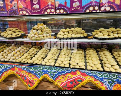 Cairo, Egitto, 24 marzo 2024: Biscotti arabi tradizionali per la celebrazione delle festività islamiche Festa di El-Fitr, Ghoriba egiziana, Kahk egiziano con polvere Foto Stock