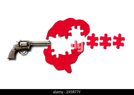 Puzzle umano a forma di cervello e revolver isolati sul bianco. Concetto di esplosione mentale o esplosione cerebrale. Foto Stock