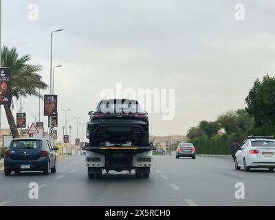 Cairo, Egitto, aprile 27 2024: Un carro attrezzi idraulico con pianale con una nuova Porsche Macan, un SUV crossover compatto di lusso (D-segmen) Foto Stock