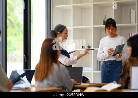 Studentessa asiatica che ha una presentazione in classe universitaria Foto Stock