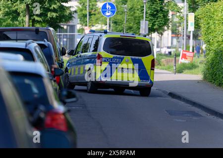 Colonia, Germania. 11 maggio 2024. Una macchina della polizia è parcheggiata in una strada ai margini del Bürgerpark a Colonia-Kalk. Una macchina della polizia attraversa una strada ai margini del Bürgerpark a Colonia-Kalk. Credito: Henning Kaiser/dpa/Alamy Live News Foto Stock