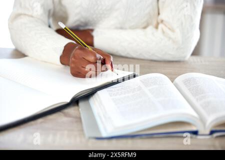 Donna, mani e libro per scrivere appunti a casa, ricerca e studente per il piano su diario. Persona femminile, idee e libri di testo per università o università Foto Stock