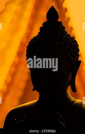 Silhouette Buddha god giallo brillante arancio dorato ornamento asiatico architettura Thailandia Foto Stock