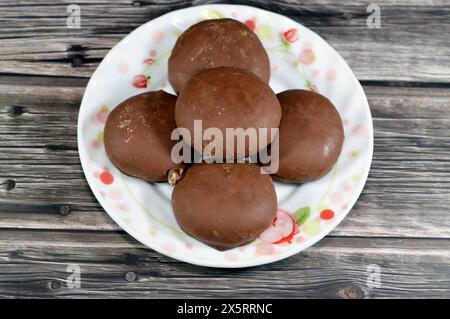 Maamoul ricoperto di cioccolato fondente marrone e ripieno di biscotti con datteri, il rivestimento di cioccolato che ricopre il biscotto dona un tas extra dolce e allettante Foto Stock