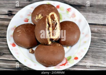 Maamoul ricoperto di cioccolato fondente marrone e ripieno di biscotti con datteri, il rivestimento di cioccolato che ricopre il biscotto dona un tas extra dolce e allettante Foto Stock