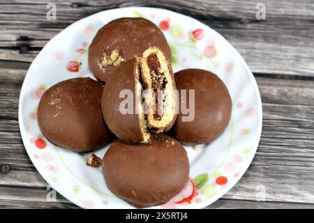 Maamoul ricoperto di cioccolato fondente marrone e ripieno di biscotti con datteri, il rivestimento di cioccolato che ricopre il biscotto dona un tas extra dolce e allettante Foto Stock